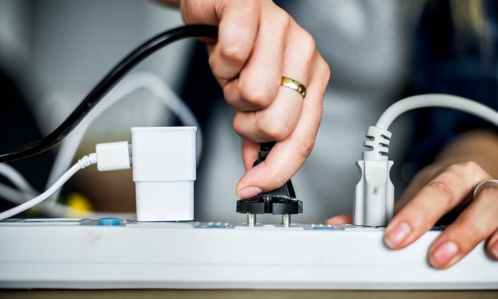 Woman plugging in cords to power strip