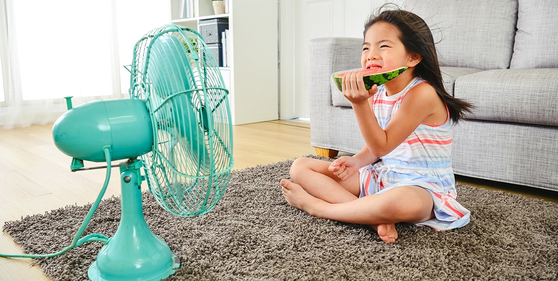 Little girl cooling off in front of a fan