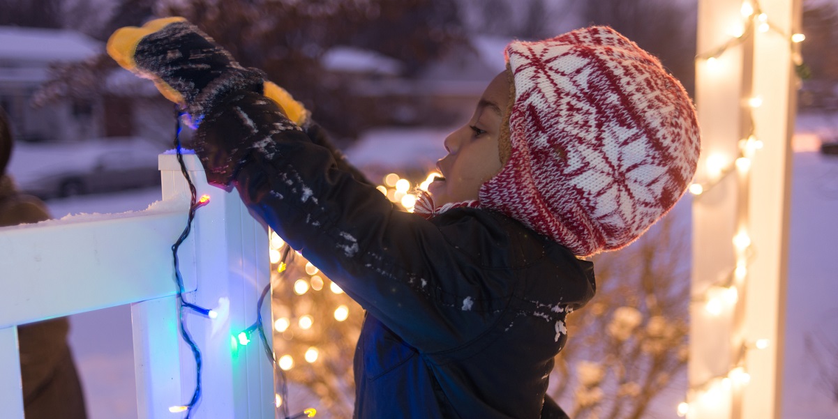 Child hanging holiday lights