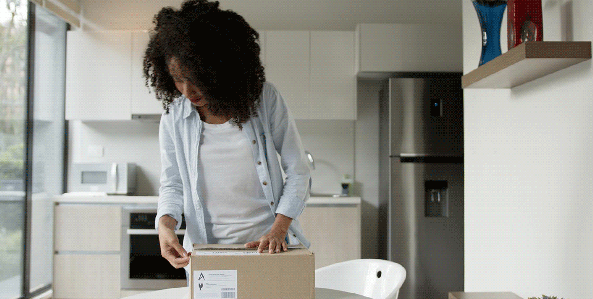 Animated GIF of woman opening a package and throwing her hands up in celebration