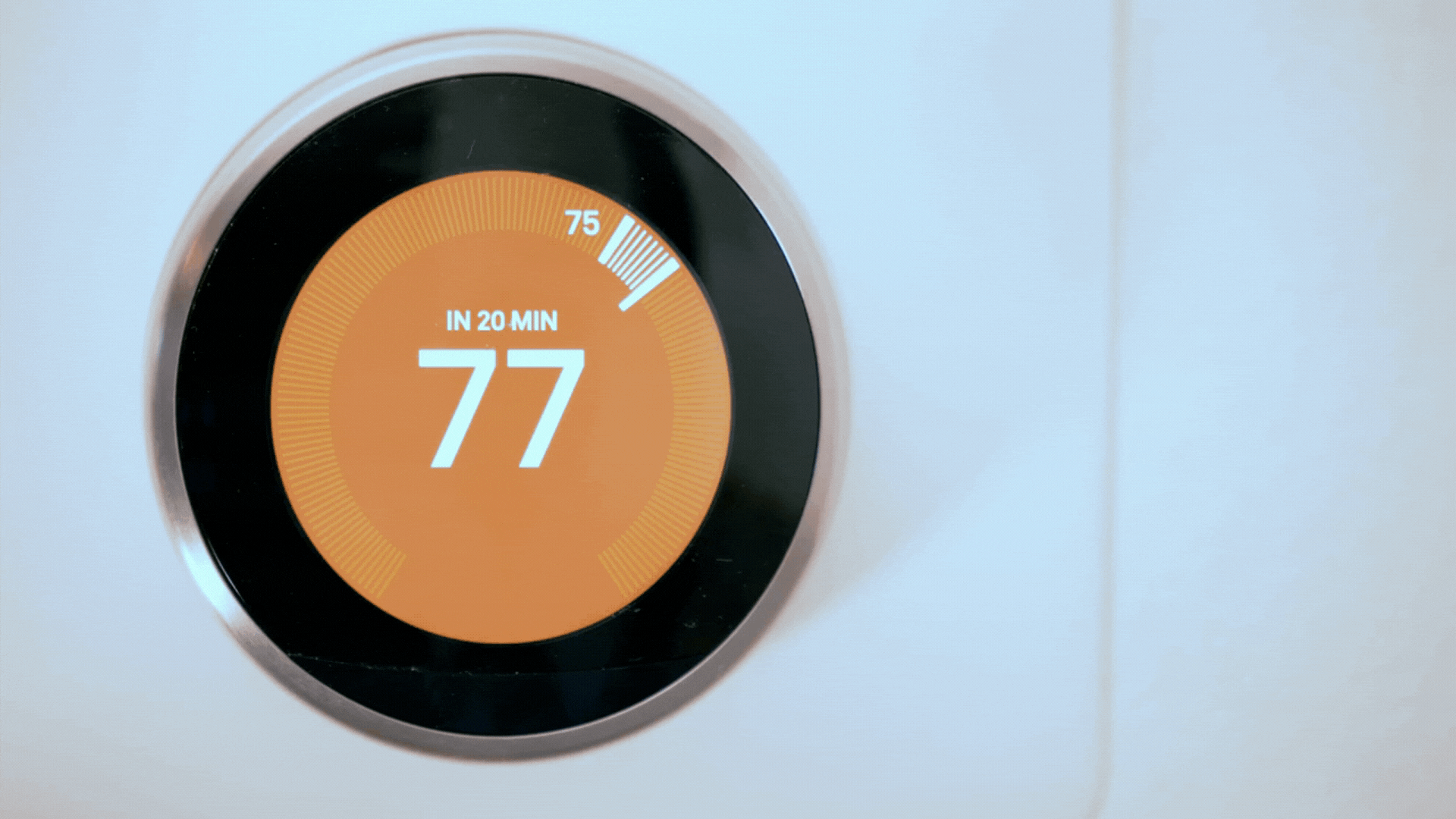 hand turning down smart thermostat