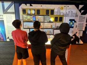 A group of three kids learning with PPL Electric's new solar panel exhibit.