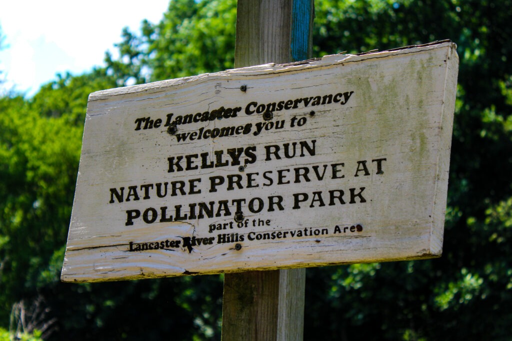 A wooden sign outside of Kellys Run Preserve near Lancaster, Pennsylvania, that welcomes folks to the Pollinator Park.