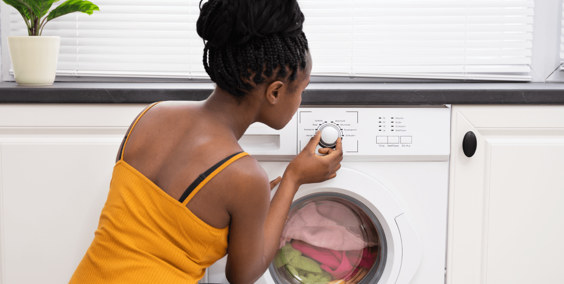 A woman adjusting the dial on a front-load washer