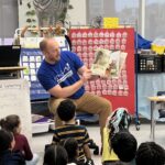 PPL employee volunteer reading to students