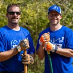 Employee volunteers with shovels