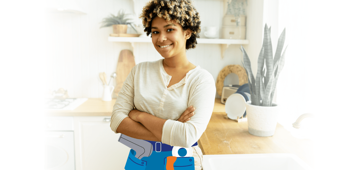Smiling woman standing in a kitchen wearing an illustrated toolbelt with DIY tools