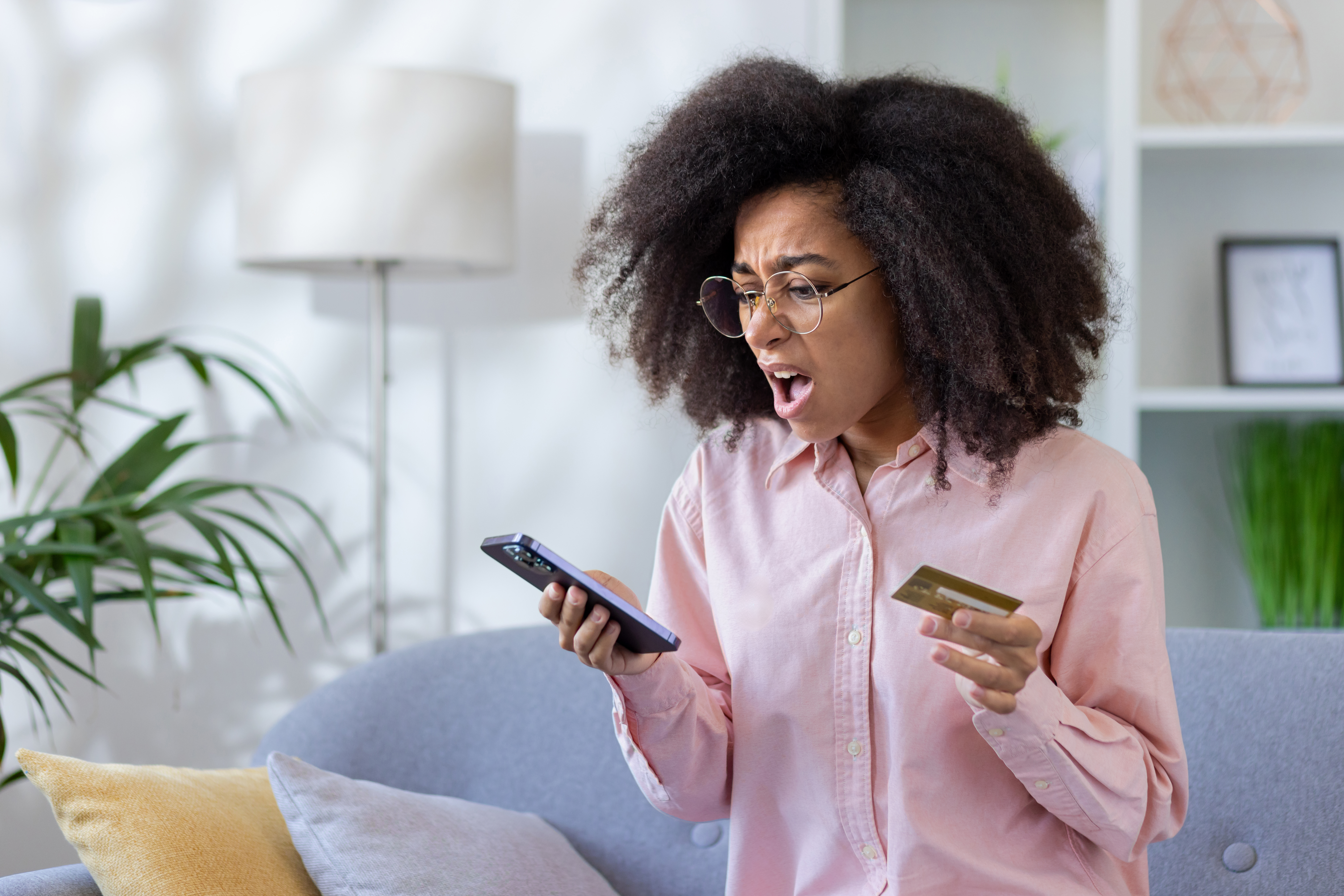 Person reviewing a utility bill while declining a suspicious phone call from an unknown number marked as "Potential Scam"