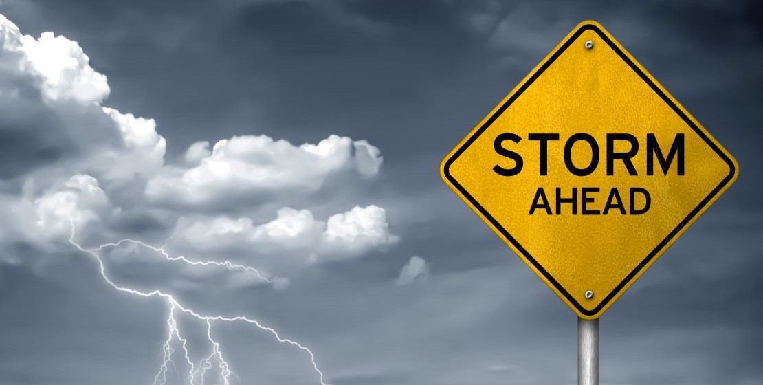 A sign that reads "storm ahead," coupled with clouds and lightning