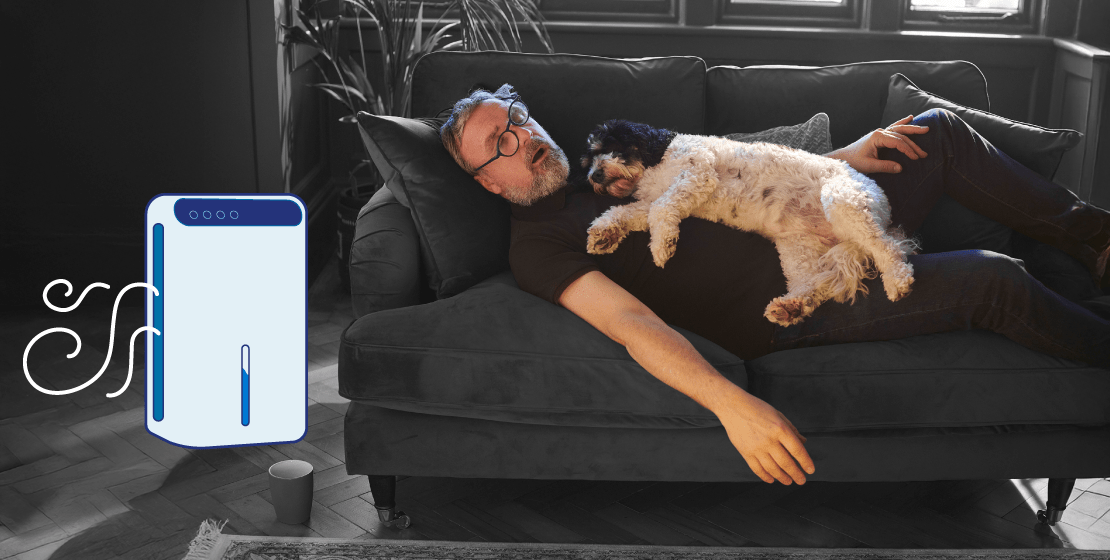 A man napping on his couch with his dog asleep on his chest, next to an illustrated dehumidifier