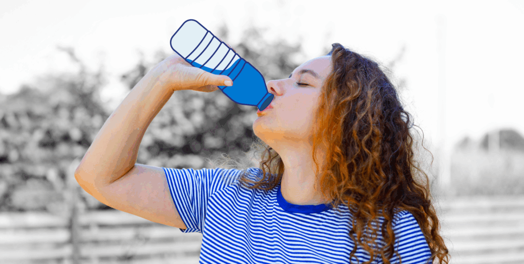 A woman drinking from an illustrated water bottle while outdoors
