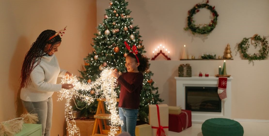 A family decorating in their living room in front of their holiday tree.