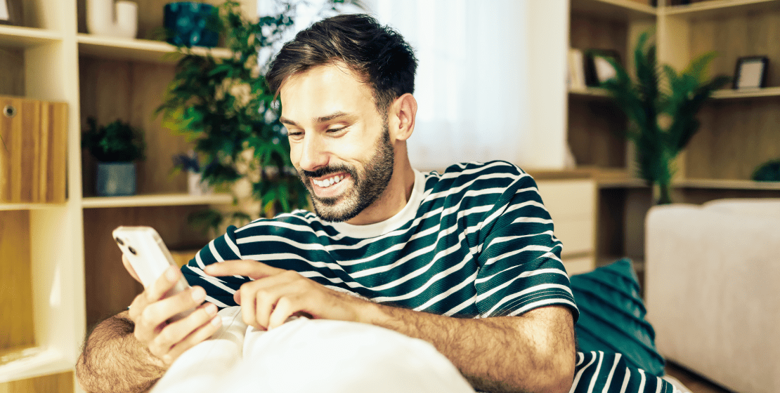 Person sitting on a couch using a mobile phone