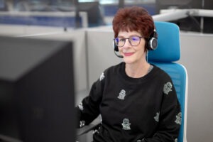 woman wearing headset looking at computer 